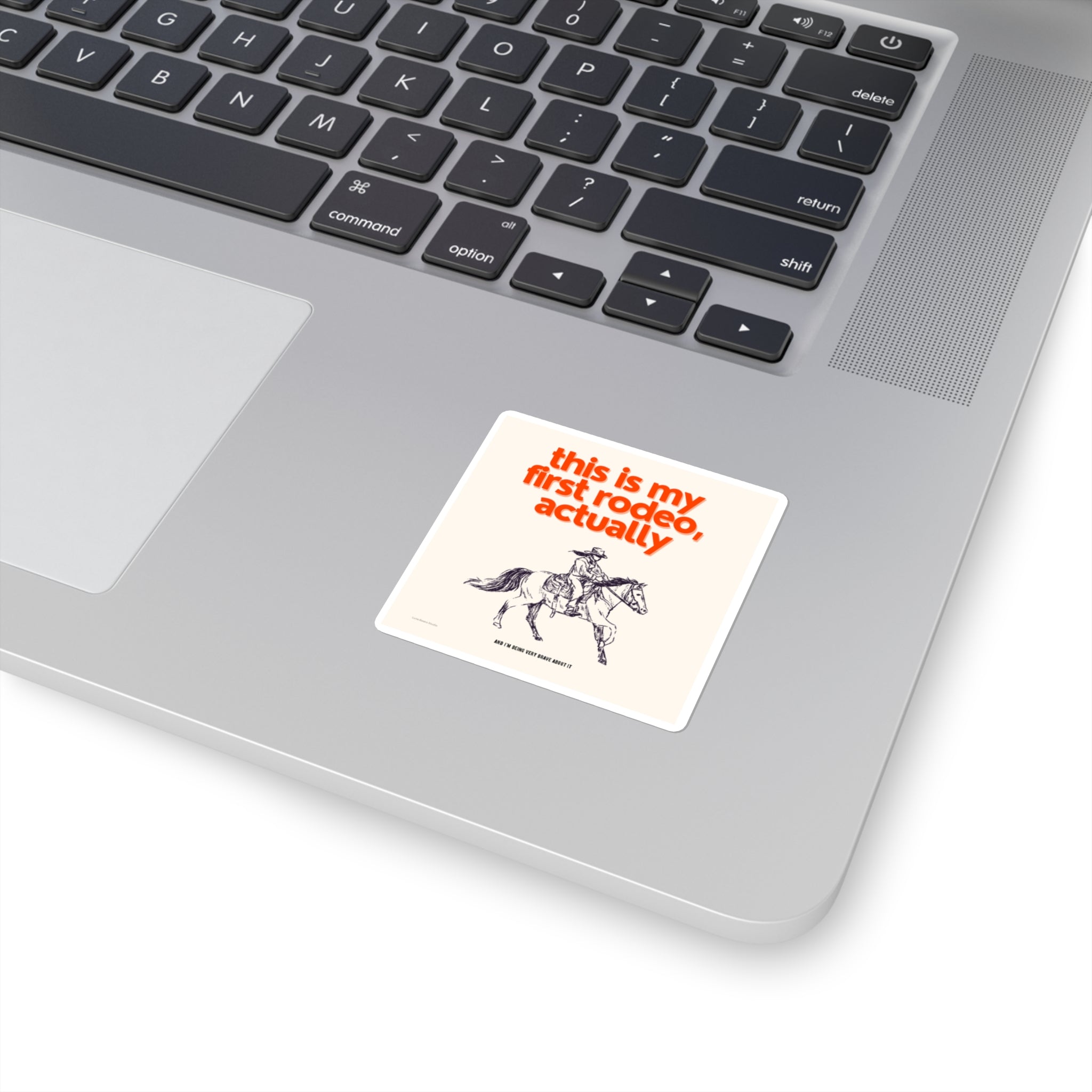 Laptop with a sticker reading 'this is my first rodeo, actually' on the palm rest area.