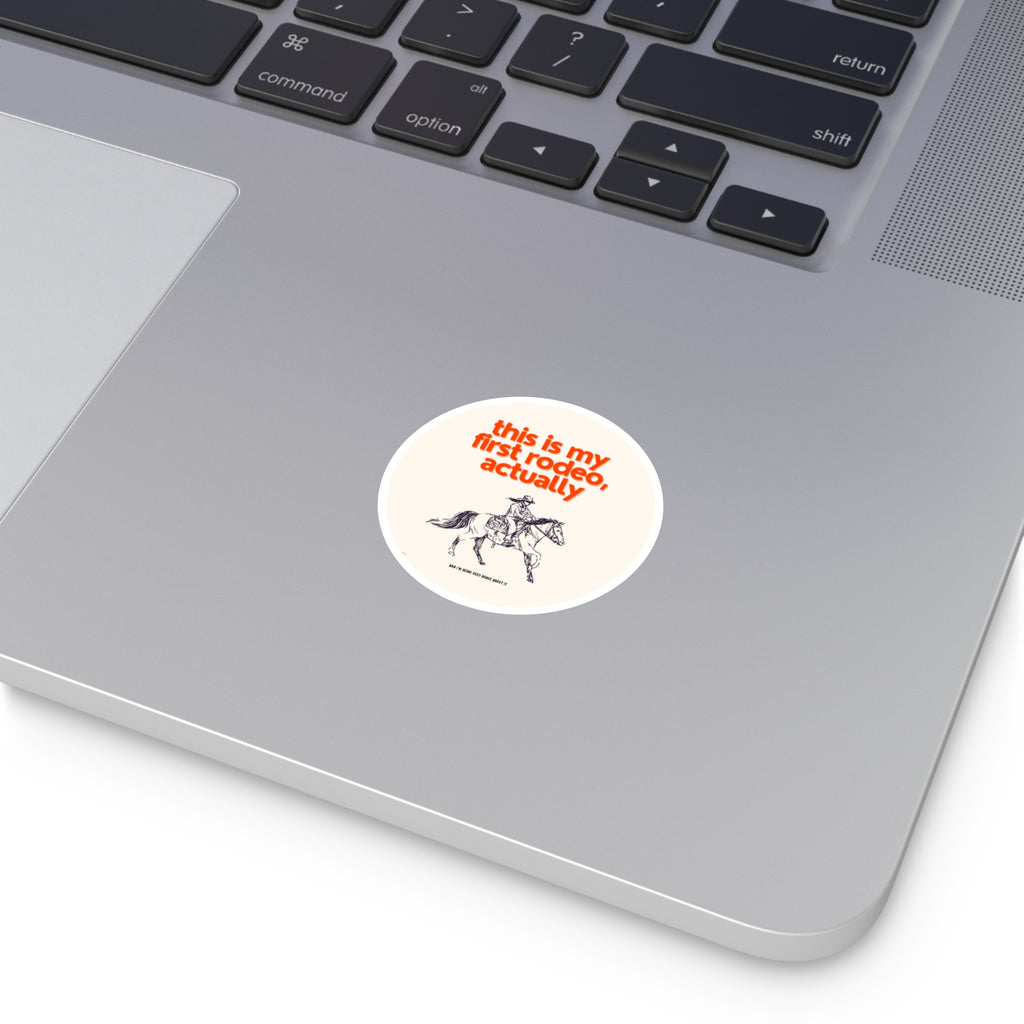 Laptop with a sticker reading 'this is my first rodeo, actually' on a white background