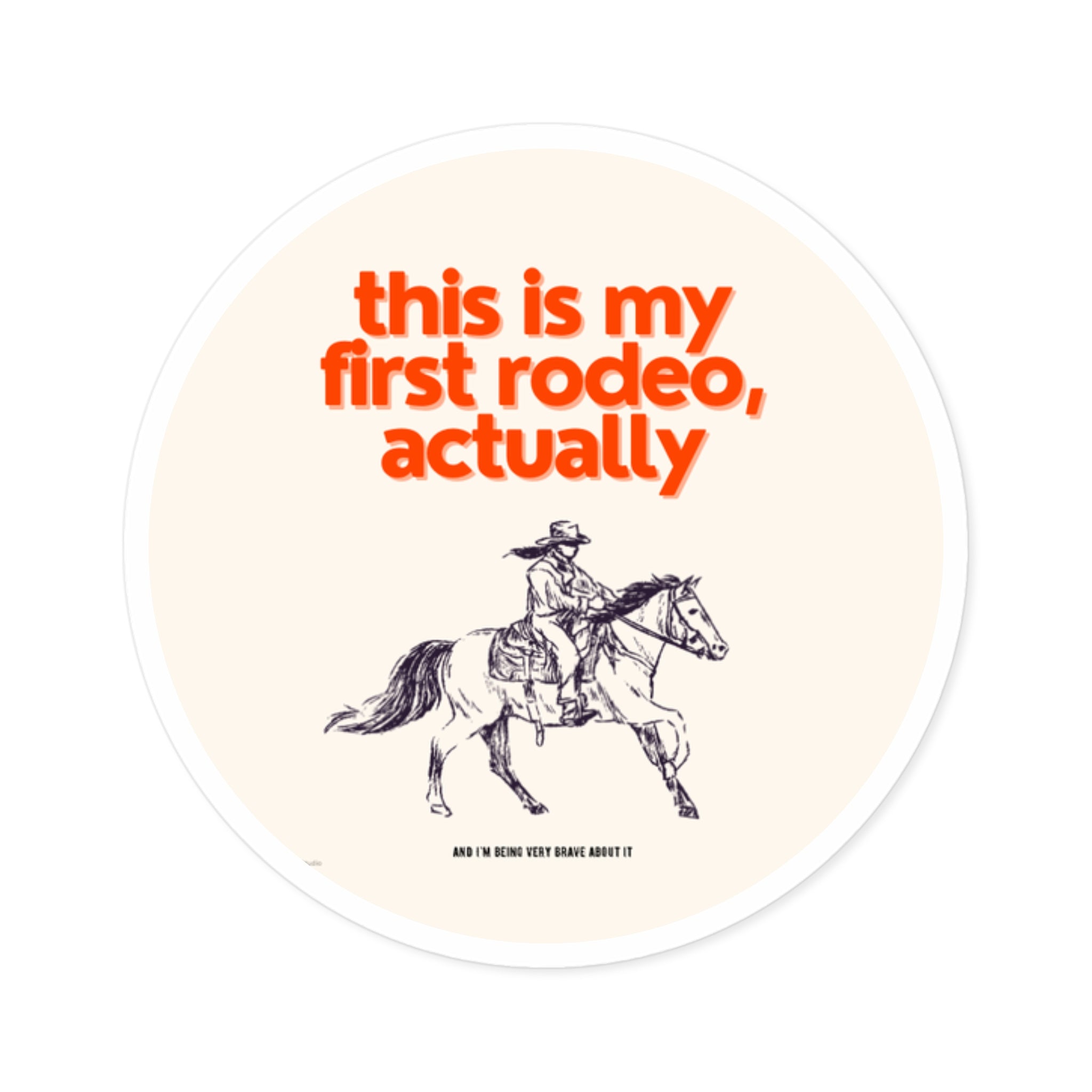 Circular sticker with a cowboy riding a horse and text 'this is my first rodeo, actually' on a beige background.
